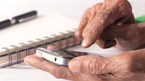 persona de edad avanzada que utiliza un teléfono inteligente