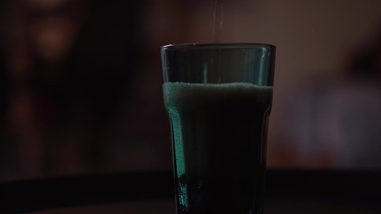 Primo piano di Coca Cola versata in un bicchiere blu, profondità di campo ridotta