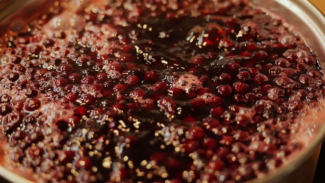 Rich crimson dye bubbles as cranberries boil with onion skins in rustic kitchen