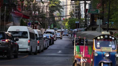 a tuk tuk moves through congested city streets.