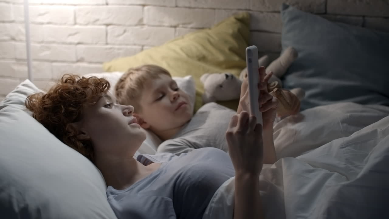 мать лежит с сыном в кровати