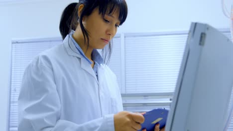 female scientist looking at clipboard 4k