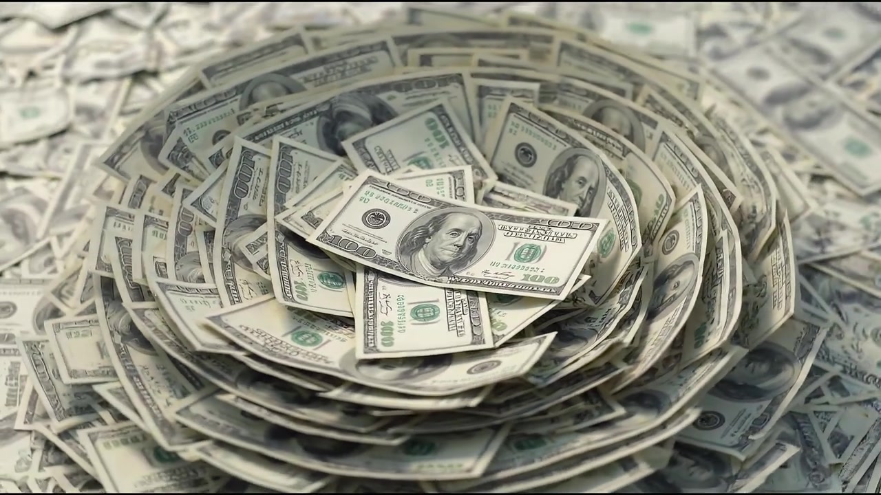 Pila di banconote di dollari statunitensi disposte a cerchio, che simboleggiano ricchezza, risparmi e finanza.