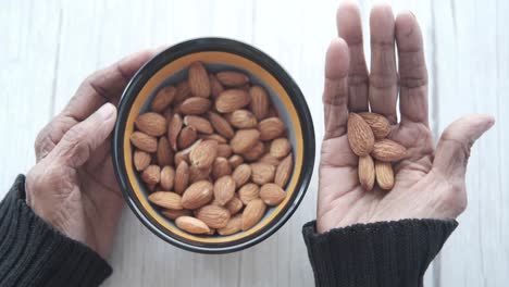 almonds in a bowl and hands