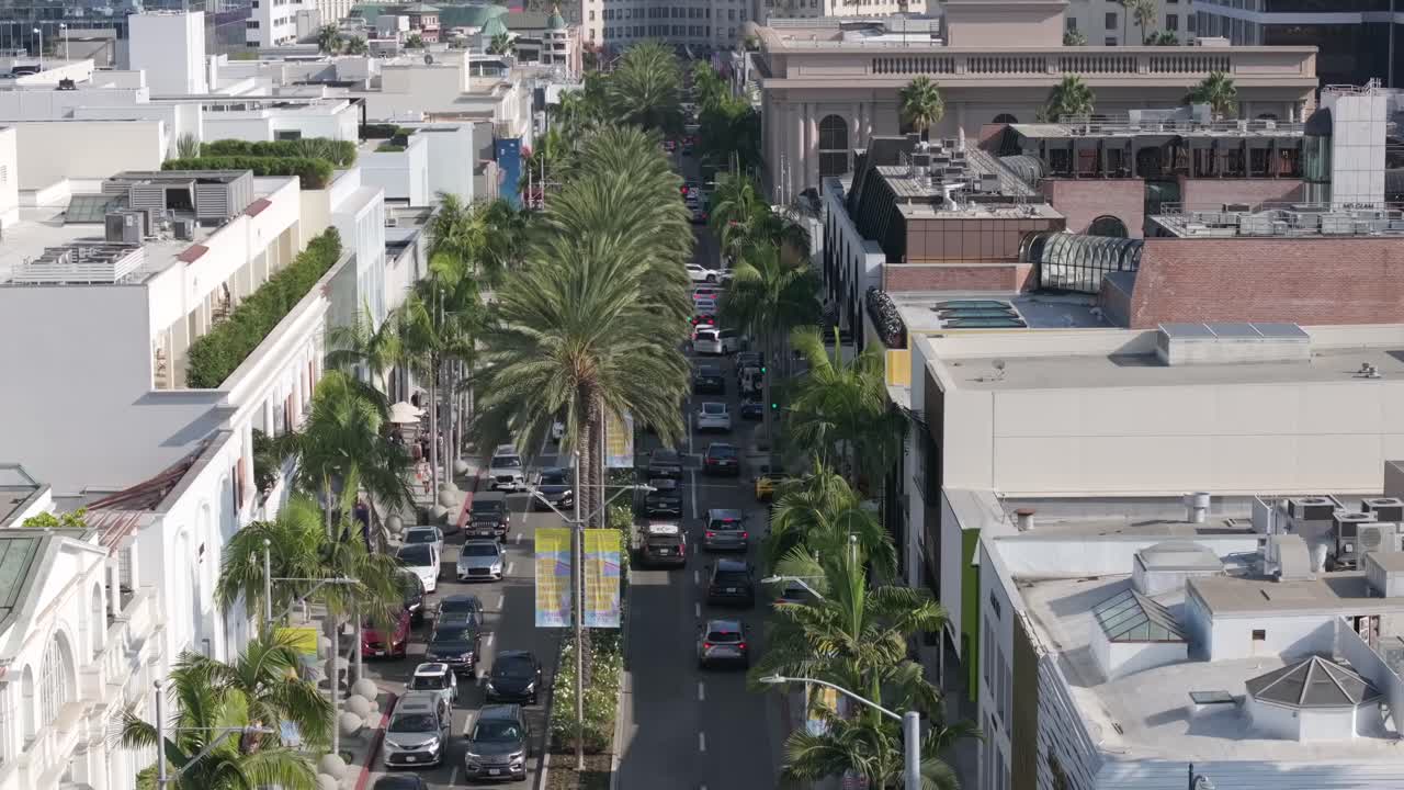 Aerial rising view of Rodeo Drive, palm tree lined street of luxury stores in Beverly Hills, California