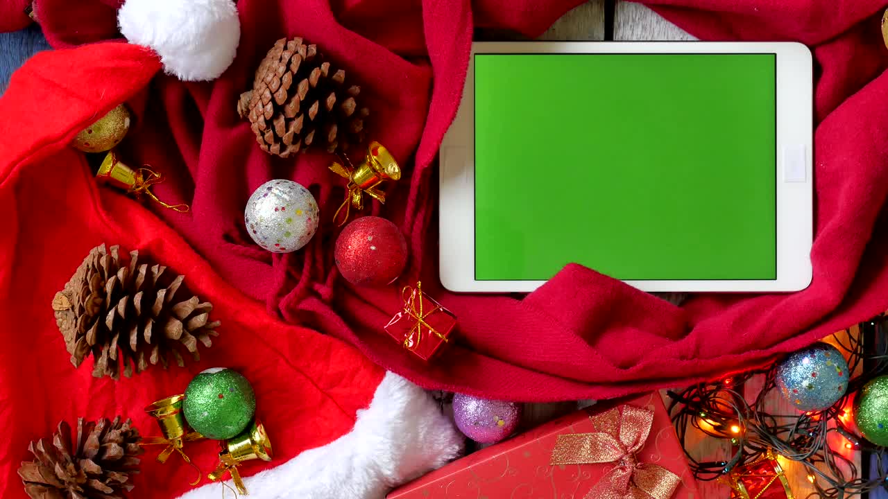 vista superior de la tableta con pantalla verde y decoración de navidad en la mesa.