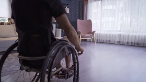 disabled young man watching out of the window of the house.