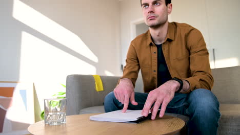 ciego leyendo un libro en braille mientras se sienta en el sofá en casa 1