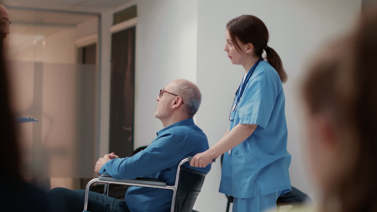 Medical staff assisting a patient in a wheelchair