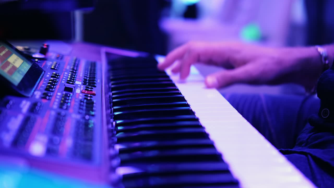Musicians playing at a wedding. Man is playing synthesizer. Stage lights