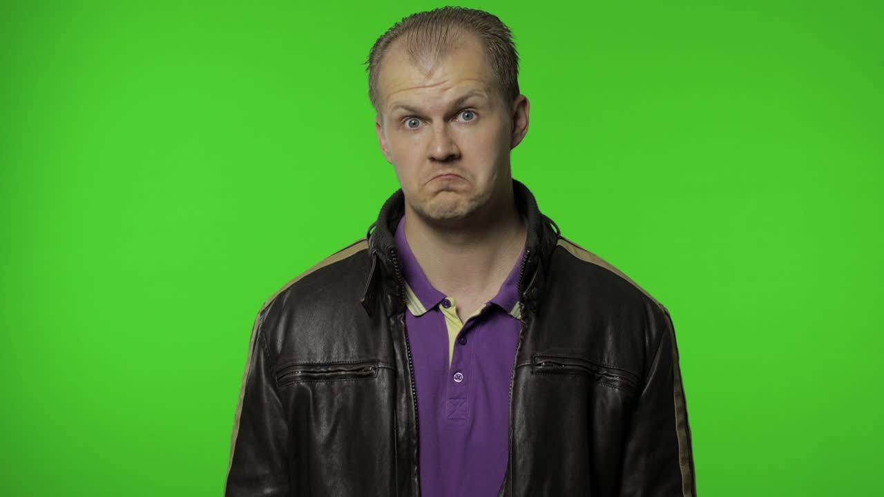 hombre rocker confundido mirando a su alrededor, haciendo la elección, decisión difícil. tipo motociclista en la llave de croma