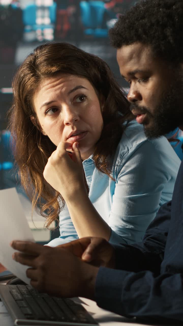 Vertical video Manager at office desk next to accountant checking documents