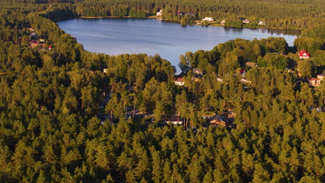 aerial flying backwards tilt up shot revealing lake langstini on summer day, latvia