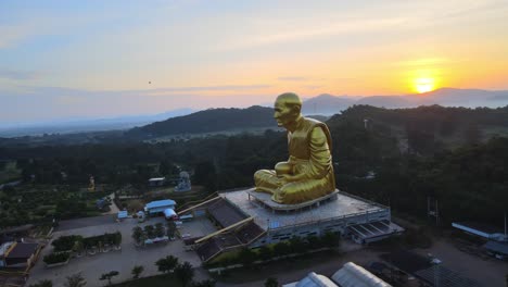 Imágenes-Aéreas-De-Drones-De-4k-De-Una-Enorme-Estatua-De-Monje-Rodeada-De-Montañas-De-Khao-Yai-Al-Atardecer-En-Tailandia