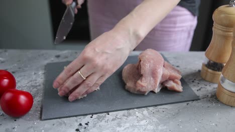 mujer preparando pecho de pavo crudo
