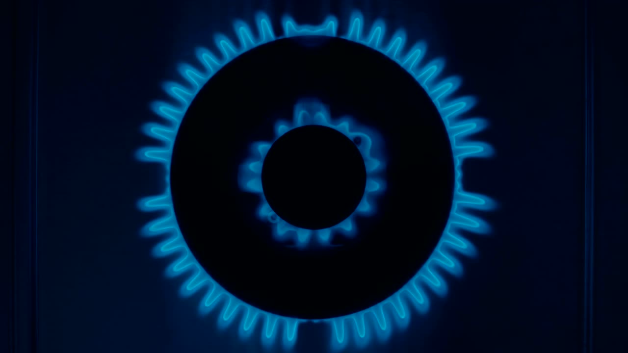 가스 스토브 버너는 어 속에서 파란 불꽃으로 불타오릅니다.