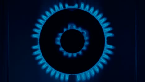el quemador de la estufa de gas se enciende con una llama azul en la oscuridad