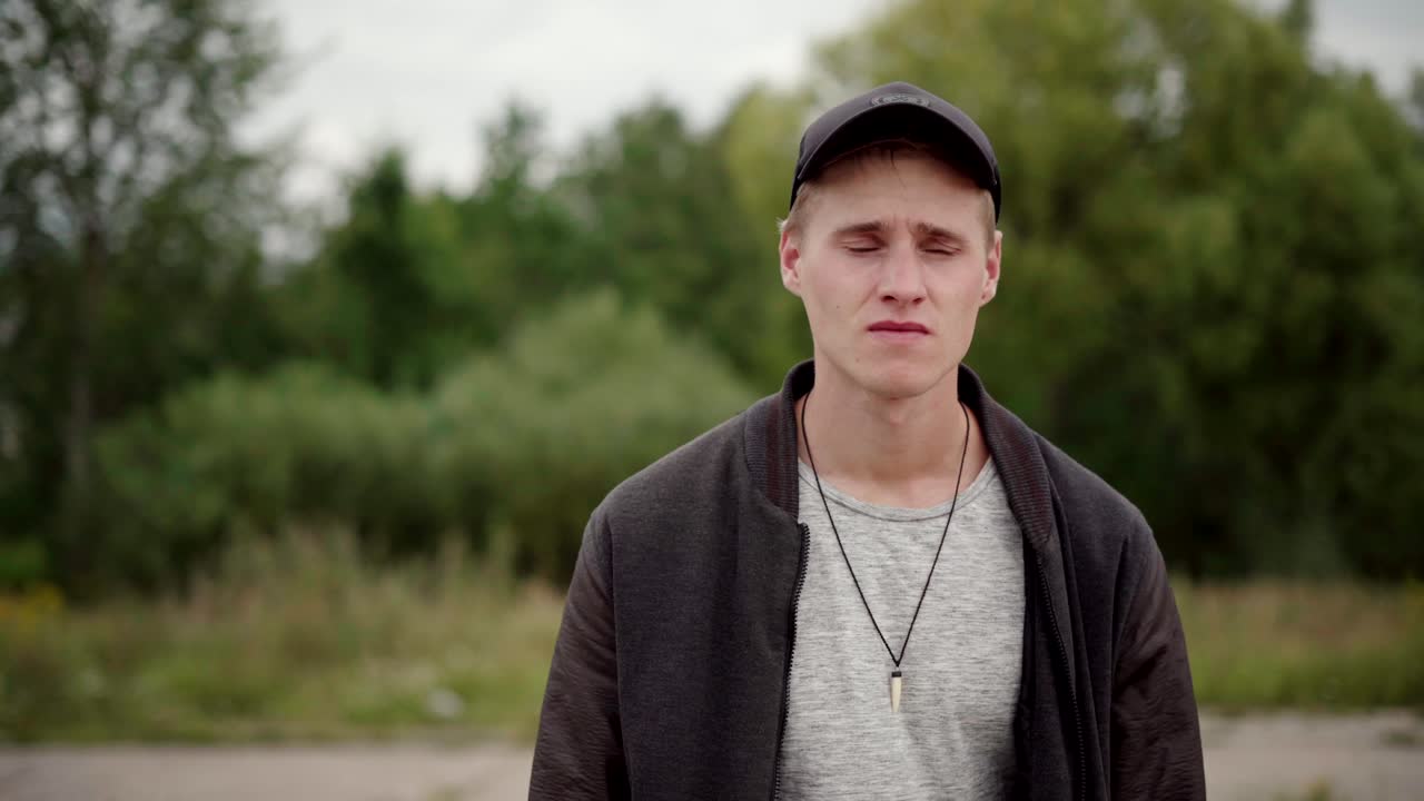 A young male walking along aa abandoned concrete train platform