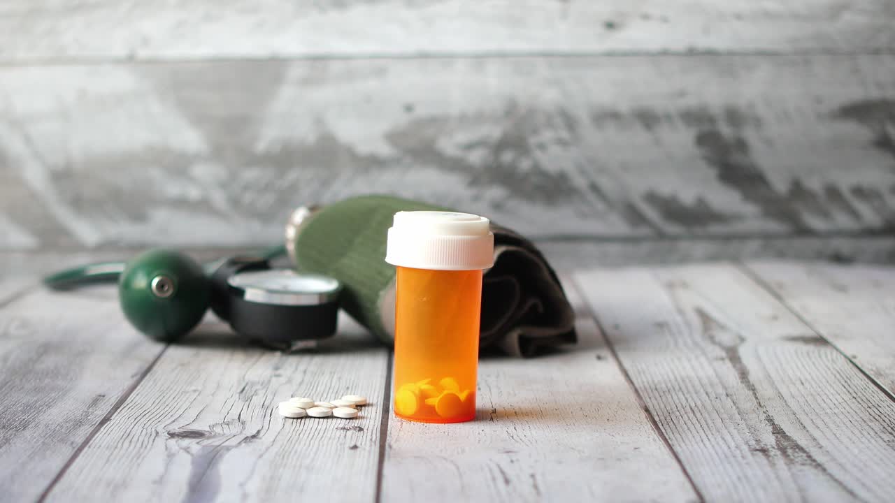 의약품 용기와 혈압 계산기가 테이블 위에 있습니다.