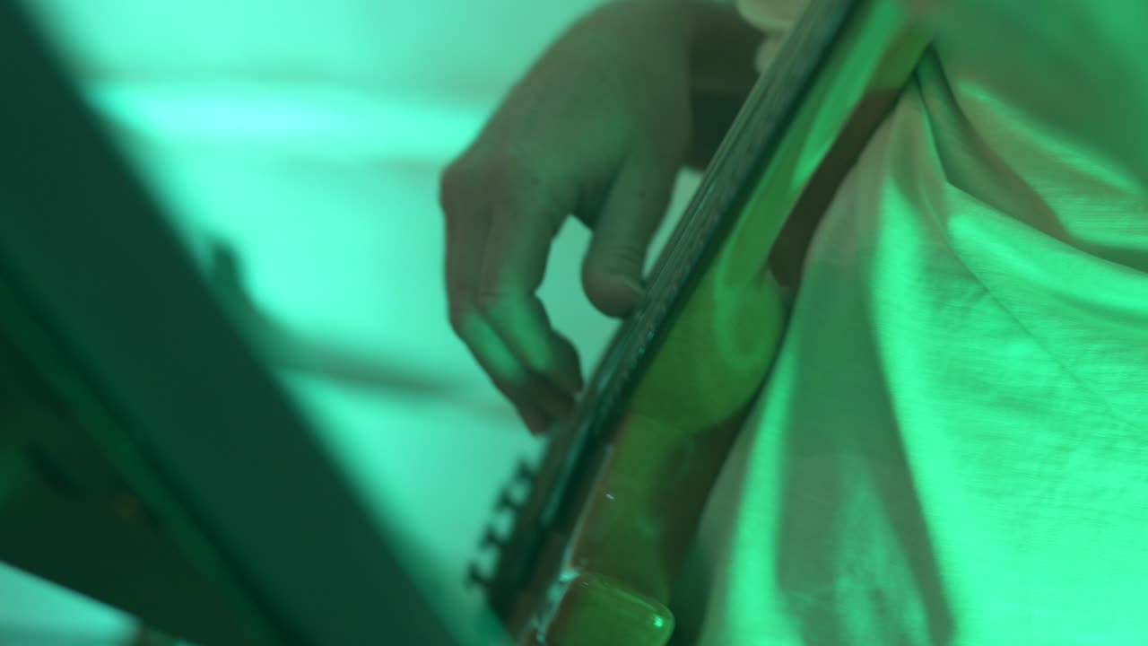 primer plano de las manos del bajista durante el concierto