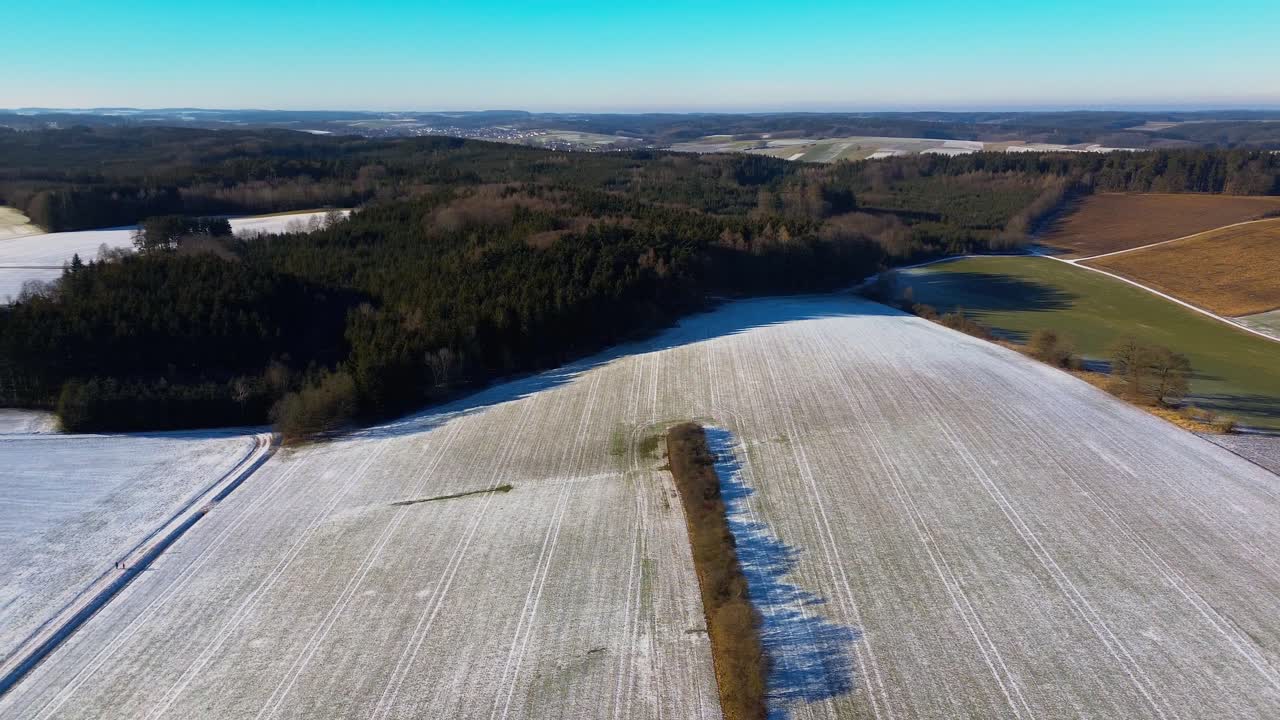 Vinterens preg på kupert jordbrukslandskap ved daggry