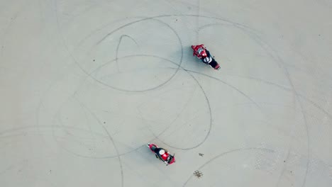 top view of two professional motobikers racing highspeed on a road in a circle way. bikers on their motorcycles training riding outdoors. aerial view.
