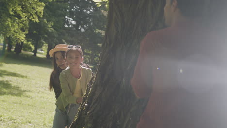 family playing hide and seek in the park
