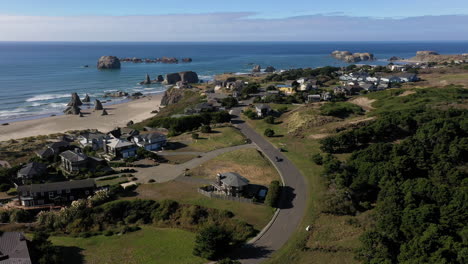 aerial circle pan shot over houses on bandon beach on sunny day