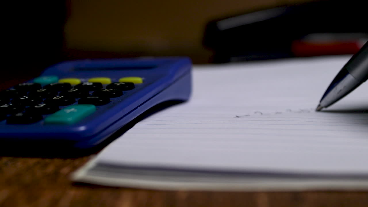 un contador agregando números en un bloc de notas con calculadora