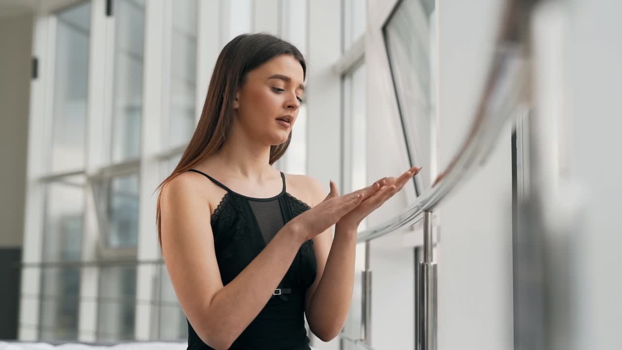 hermosa mujer aplica crema en sus manos y masajea suavemente sus manos