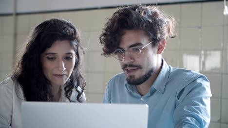 front view of focused young woman talking with confident colleague