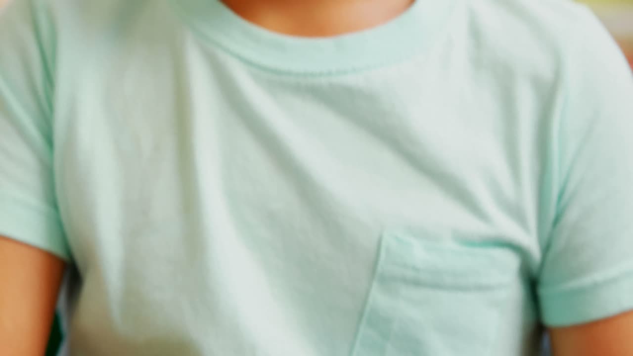 Vista frontale di uno scolaro caucasico non vedente che legge un libro in Braille al banco nell'aula a scuola 4k