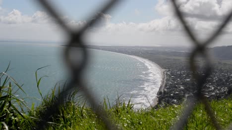 Espectacular-Vista-Al-Mar-Detrás-De-Una-Valla-De-Tela-Metálica-Borrosa-En-Primer-Plano