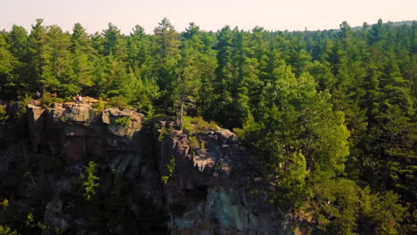 gorgeous 4k aerial shot of a forest and rocky cliffs on a beautiful sunny day