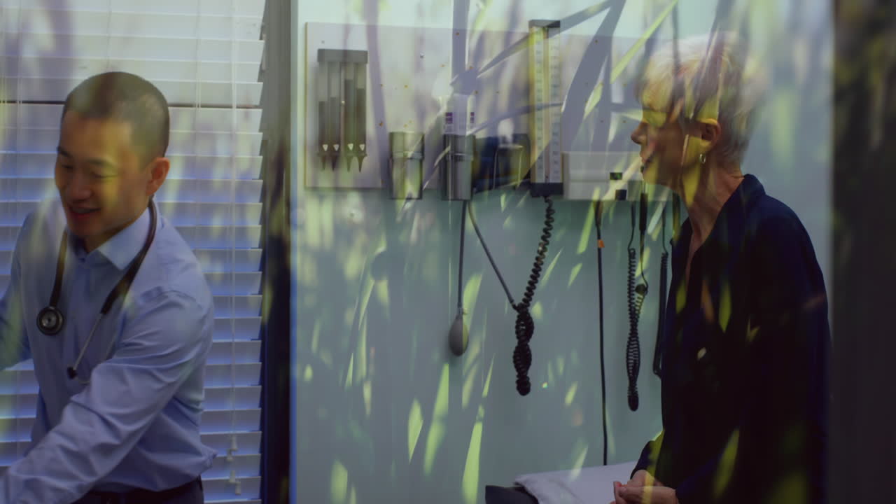 médico masculino dando inhalador de asma a una mujer mayor contra la hierba que se mueve en el fondo