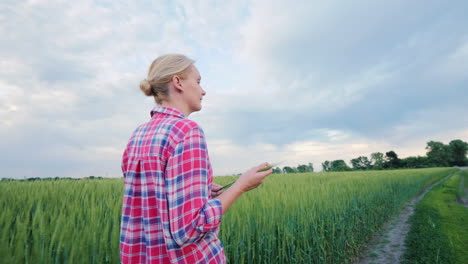 Mujer-De-Negocios-Agricultor-Hablando-Por-Teléfono-Caminando-En-El-Camino-Entre-Los-Campos-De-Trigo