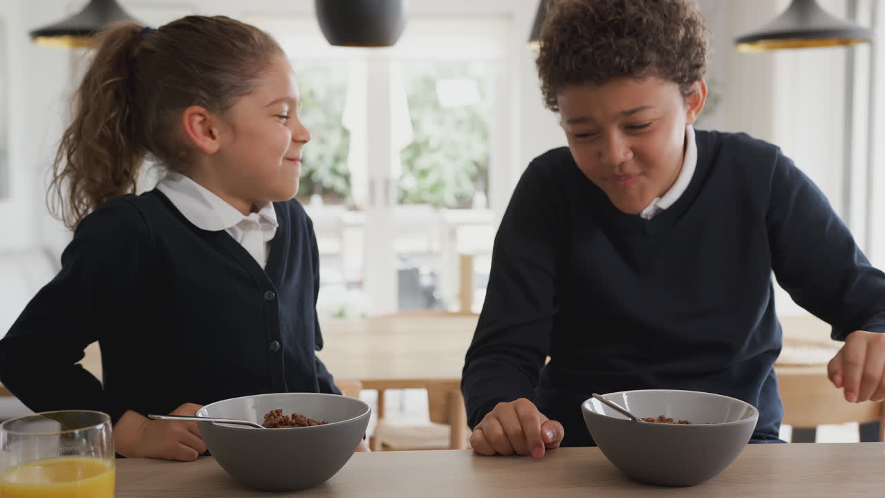 Bambini al bancone della cucina che fanno colazione dolce prima di andare a scuola.