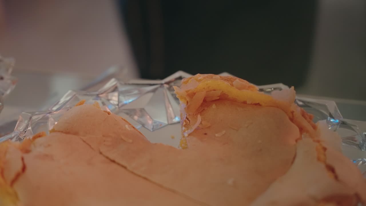 Closeup of slicing a warm flaky pastry on a clear serving plate