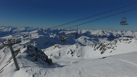 drone shot flying along a cable car with skiers in la plagne france.