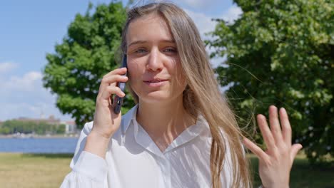 sonrisa radiante: mujer morena entusiasta hablando en el teléfono inteligente