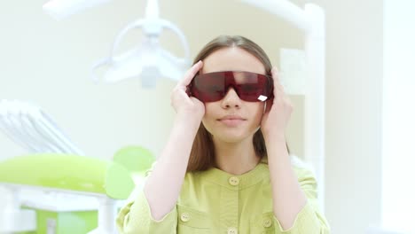 una dentista disfrazada de gafas de seguridad naranja ultravioleta.