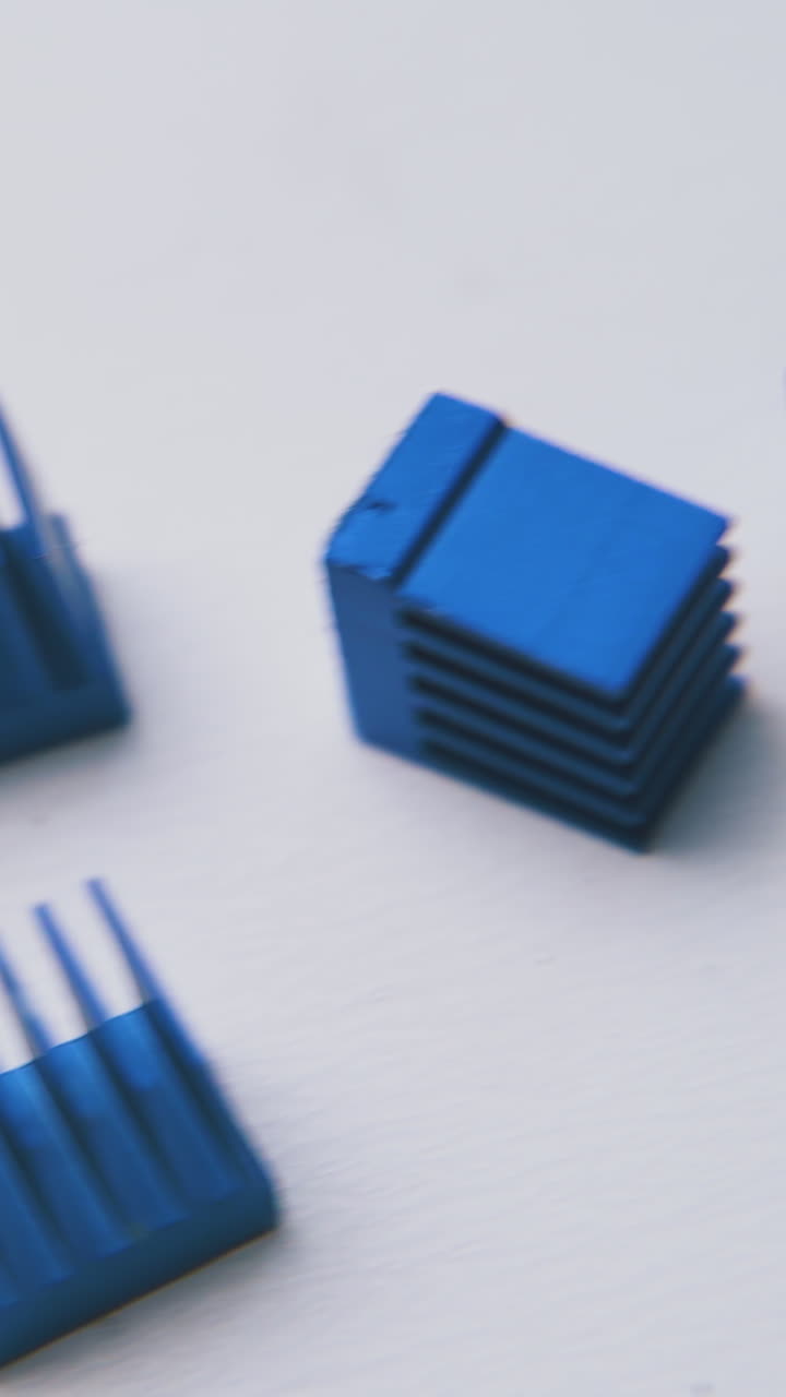 group of small blue scattered heatsinks for chips lie on clean white background extreme close view