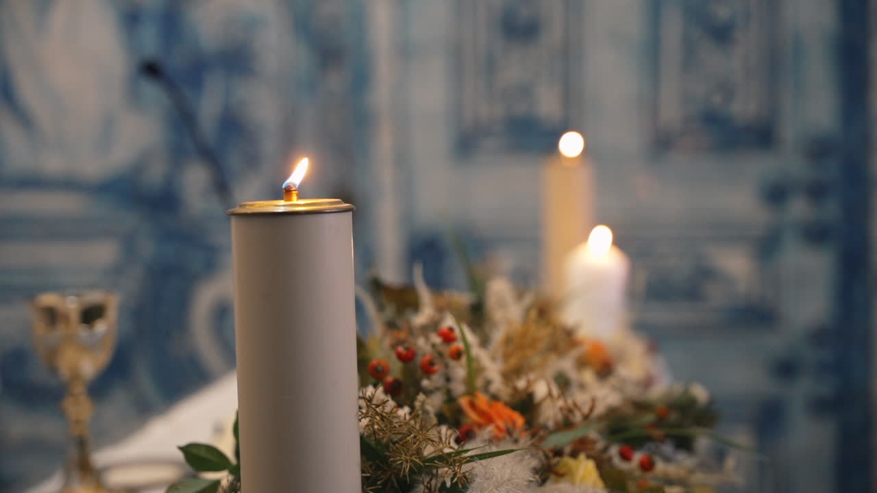 velas de altar encendidas con arreglos florales