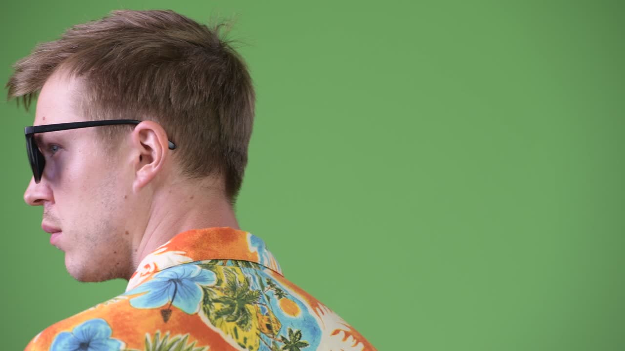 Young handsome tourist man looking back