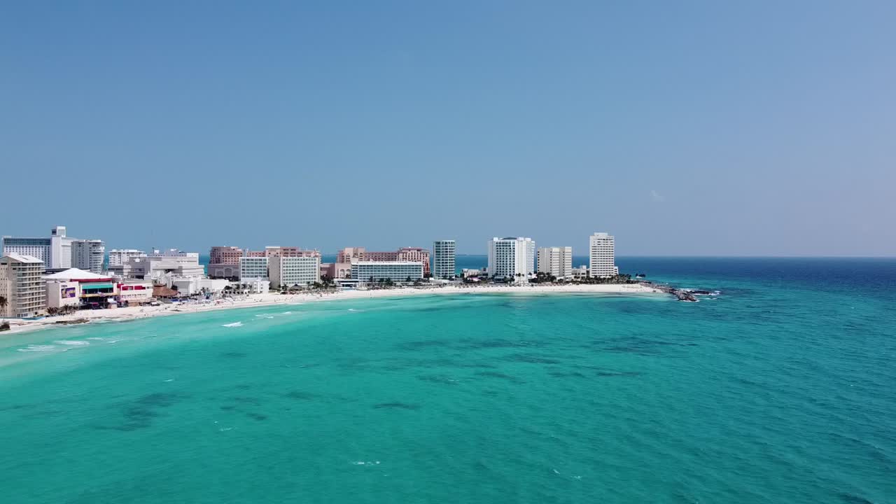 Cancun coastline with clear turquoise waters and beachfront hotels, aerial view