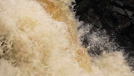 agua en cámara lenta cayendo en cascada por una cascada en una fuerza violenta de la naturaleza