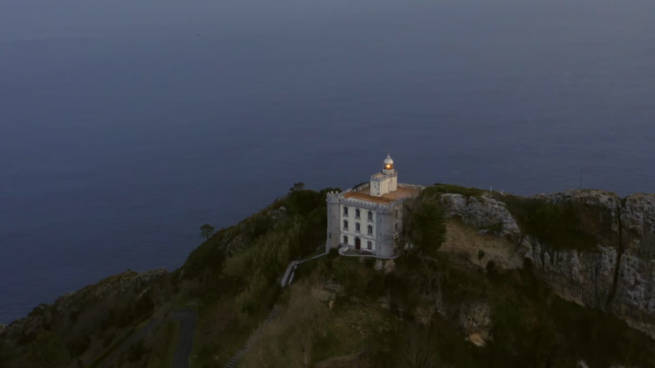 Aerial slow motion orbit around 'El Faro de la Plata' lighthouse on a cliff