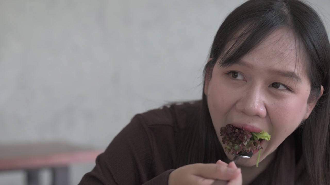 女性がランチにヘルシーなサラダを食べている。
