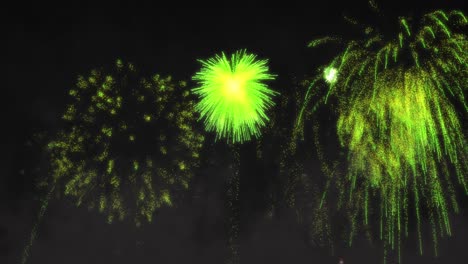 animation of green fireworks exploding on black background