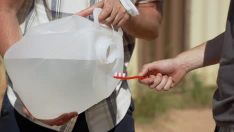 cepillado de dientes con bote de plástico y pasta de dientes